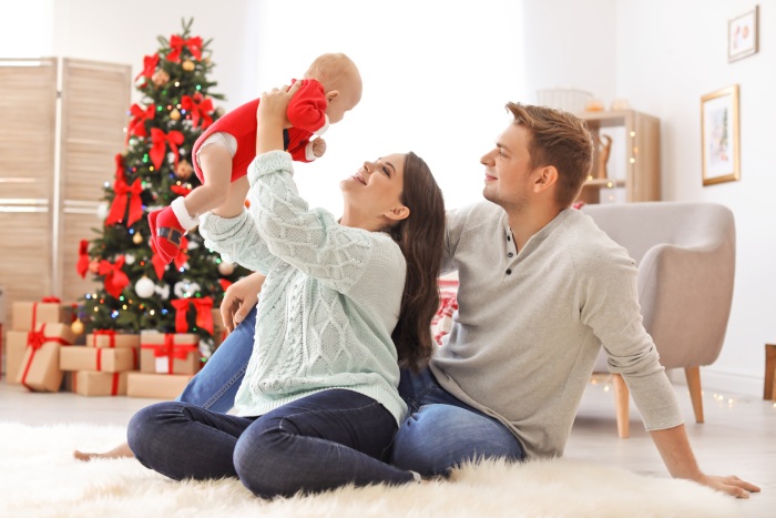 Baby girl, mom, and dad celebrating Christmas