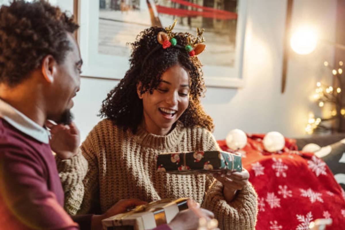 Couple wrapping Christmas presents at home 