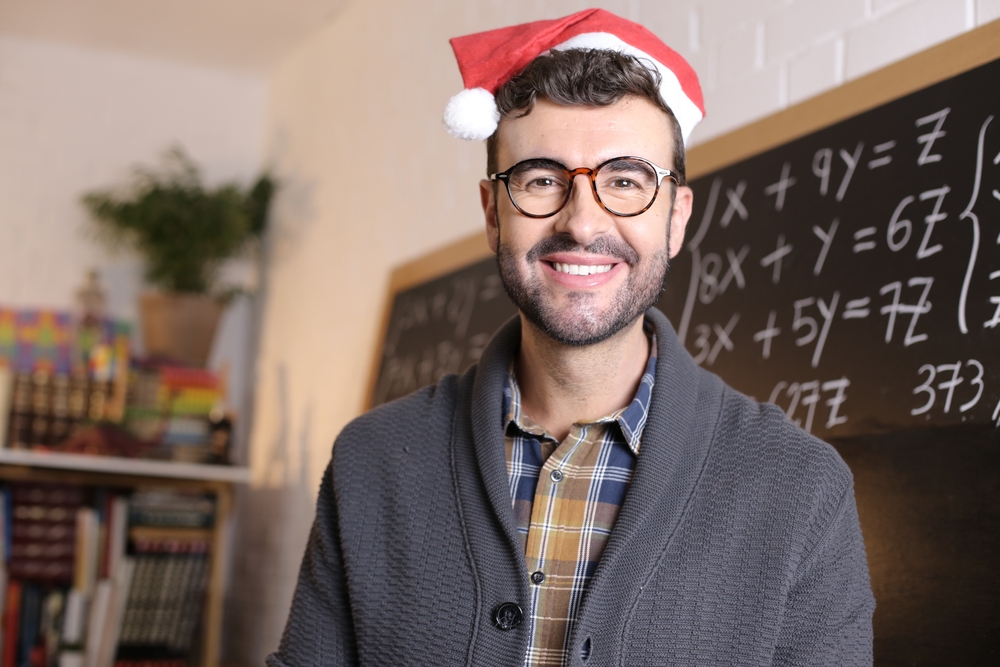 A teacher in a classroom wearing a Christmas hat