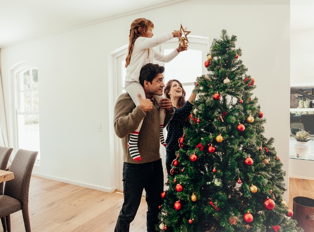 Young family decorating the Christmas tree